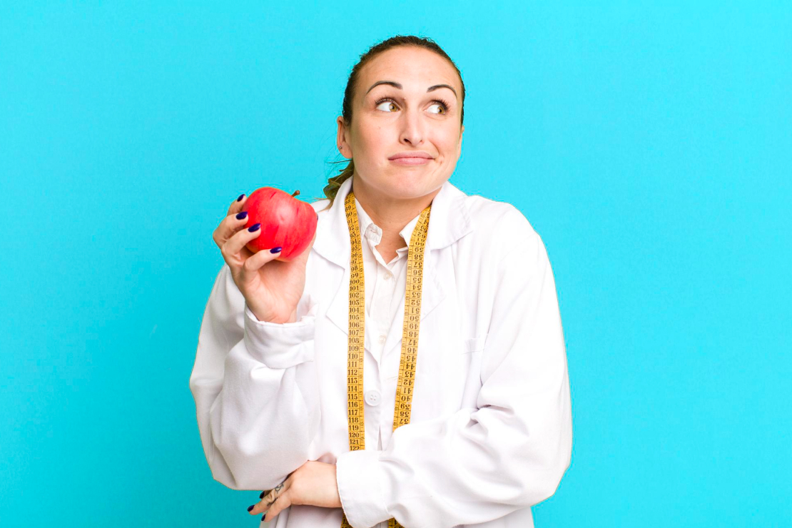 A person looking thoughtfully at a healthy meal, considering if they are in a calorie deficit.