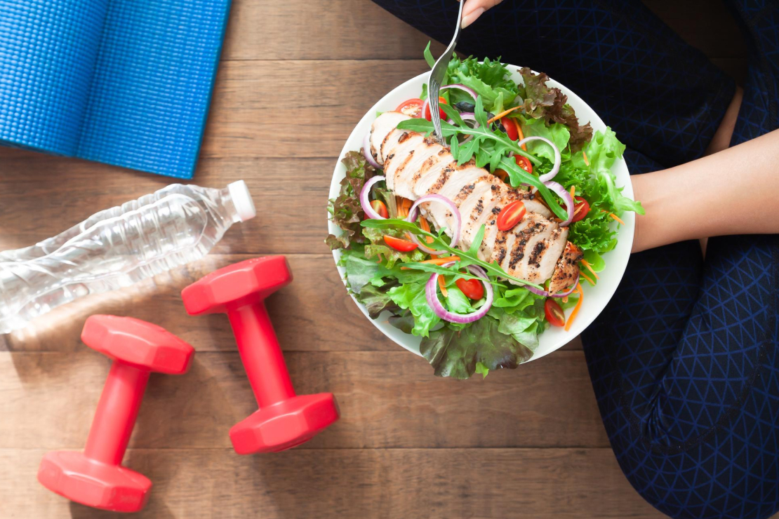 A balanced meal with workout equipment, illustrating optimal meal timing for exercise