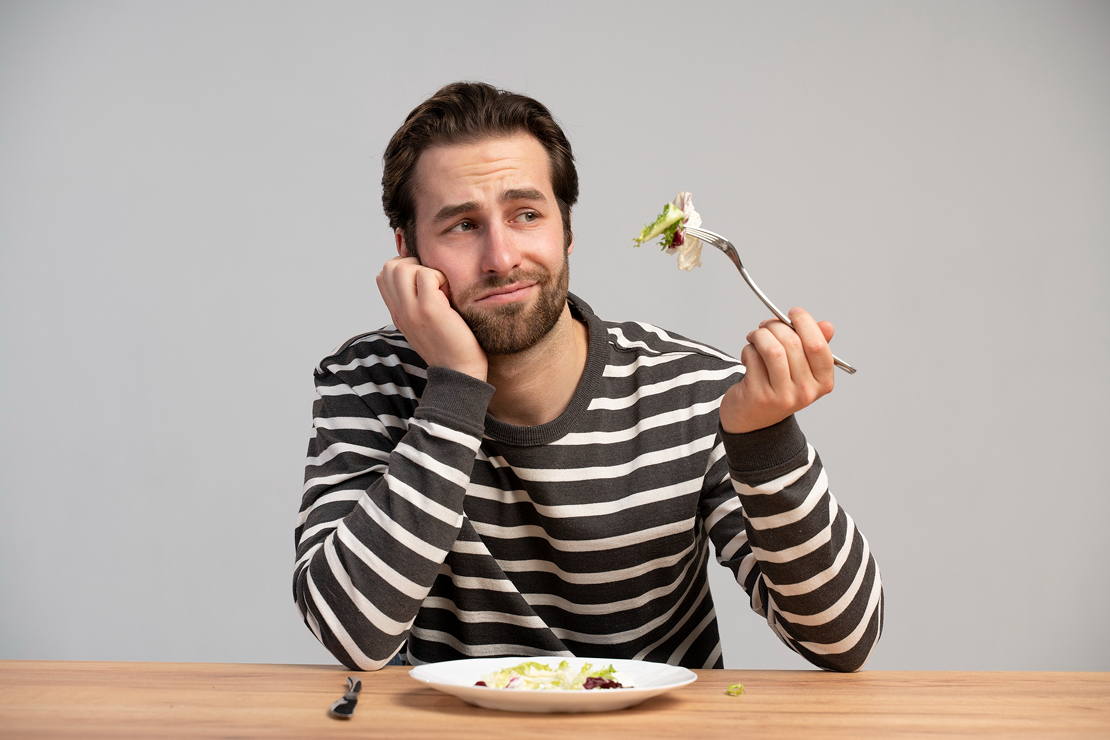A person mindlessly eating while not being hungry, illustrating the habit loop.
