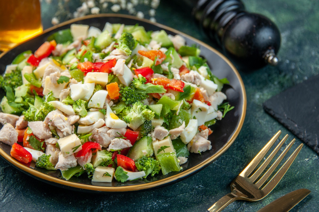 A vibrant, macro-friendly salad in a black bowl, showcasing a perfect balance of ingredients.